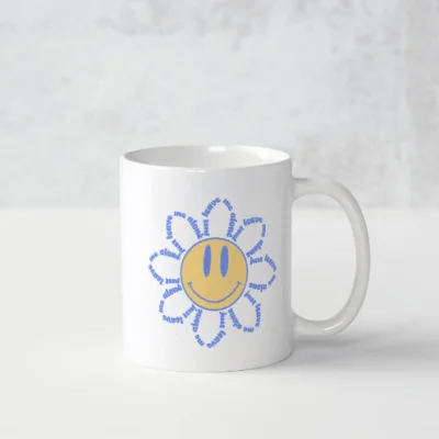 Tasse avec fleur au visage souriant. Ecriture en anglais leave me alone.